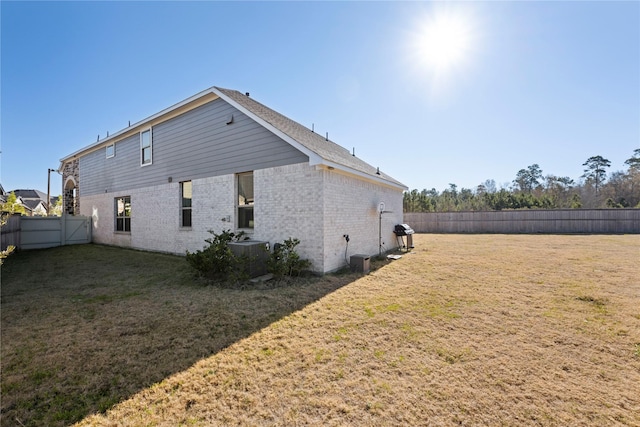 back of house featuring cooling unit and a yard