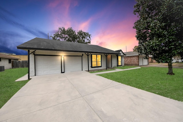 ranch-style house with a garage, central AC unit, and a lawn