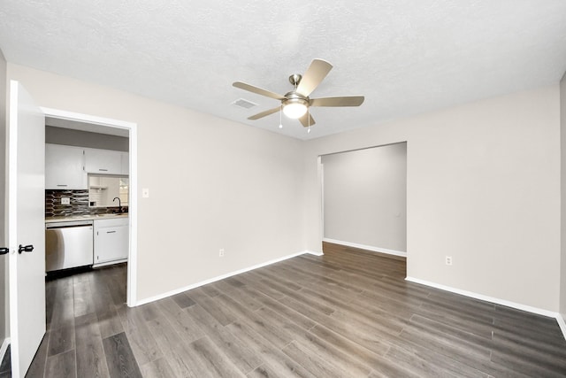 empty room with ceiling fan, wood-type flooring, sink, and a textured ceiling