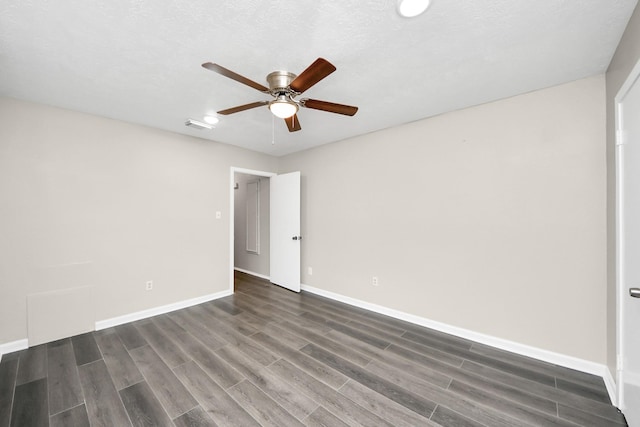 spare room featuring dark hardwood / wood-style flooring, a textured ceiling, and ceiling fan