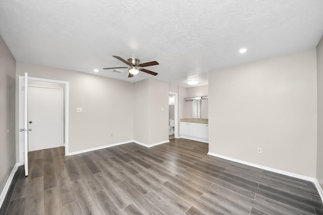 unfurnished living room with dark wood-type flooring, ceiling fan, and a textured ceiling