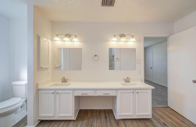 bathroom featuring hardwood / wood-style flooring, vanity, and toilet