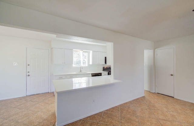 kitchen featuring sink, stainless steel stove, white cabinetry, light tile patterned flooring, and kitchen peninsula