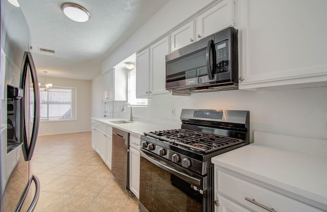 kitchen featuring light tile patterned flooring, sink, white cabinetry, a chandelier, and black appliances