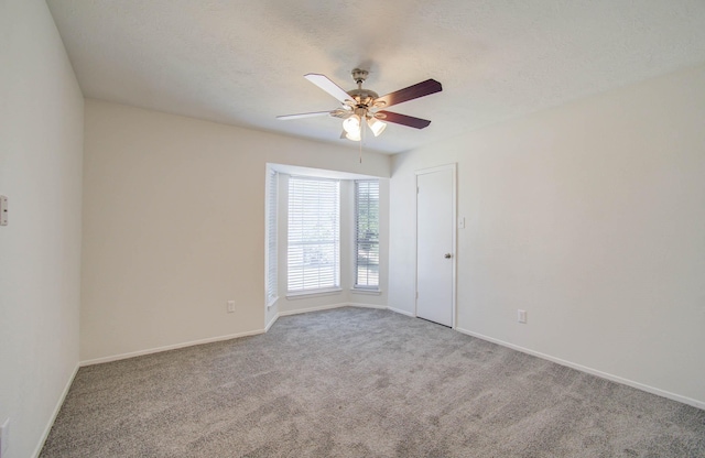 empty room with a textured ceiling, carpet floors, and ceiling fan