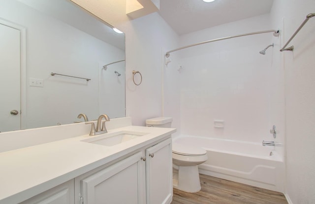 full bathroom featuring wood-type flooring, vanity, washtub / shower combination, and toilet