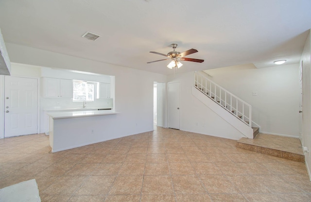 unfurnished living room featuring ceiling fan and sink