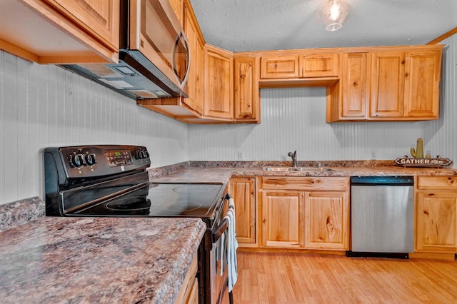 kitchen with sink, appliances with stainless steel finishes, light hardwood / wood-style floors, a textured ceiling, and light brown cabinets