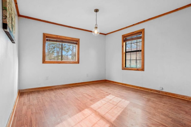 empty room with crown molding, plenty of natural light, and wood-type flooring