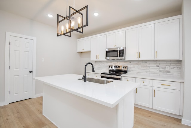 kitchen with sink, white cabinetry, decorative light fixtures, a center island with sink, and appliances with stainless steel finishes