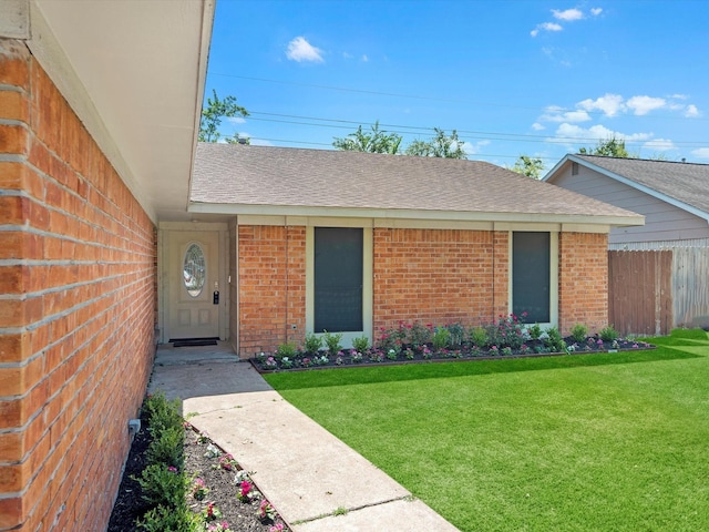 property entrance with a lawn