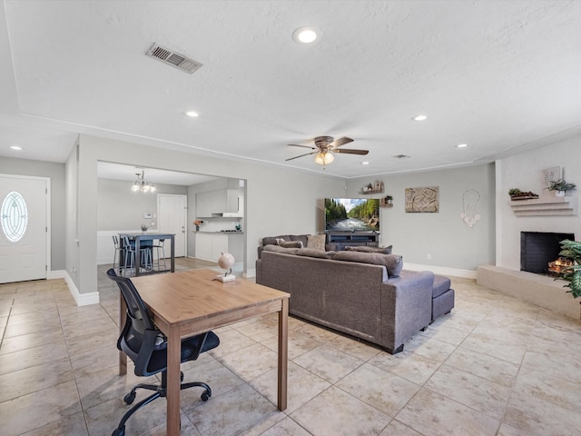 living room featuring light tile patterned floors, ceiling fan with notable chandelier, and a textured ceiling