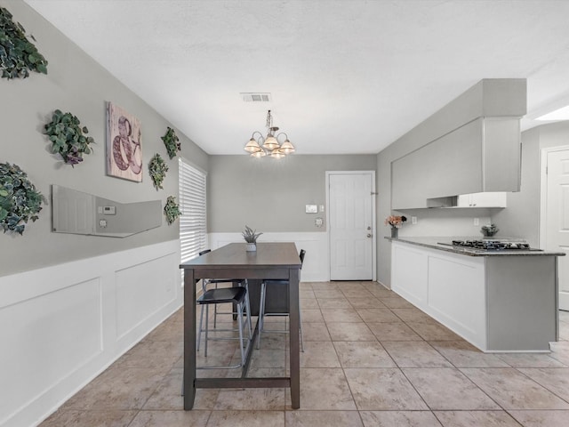 dining room with light tile patterned floors and a chandelier