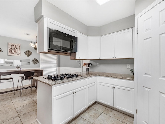 kitchen with white cabinetry, light stone countertops, stainless steel gas cooktop, and kitchen peninsula