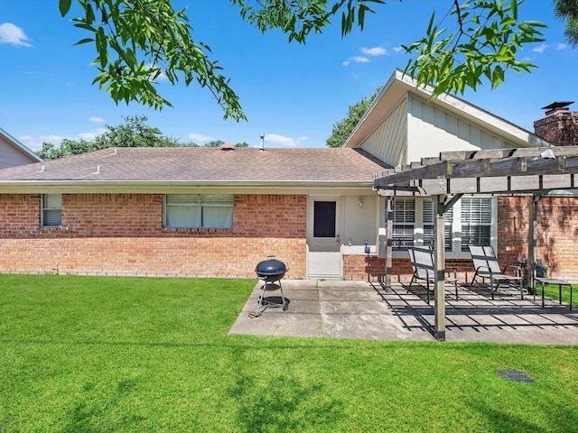 rear view of property with a patio, a yard, and a pergola