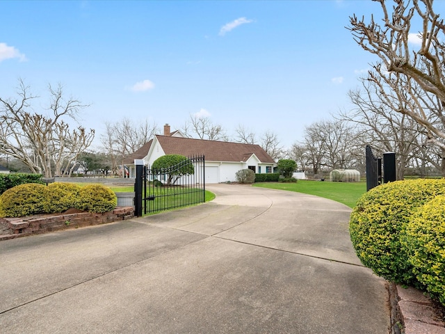 view of property exterior with a garage, driveway, a chimney, and a lawn