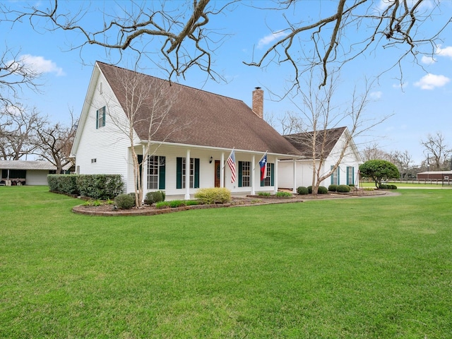 cape cod home with a shingled roof, a chimney, a porch, and a front yard