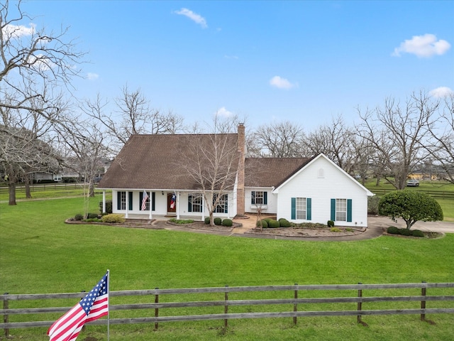 view of front of home featuring a fenced front yard, roof with shingles, a chimney, and a front lawn