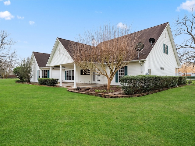 rear view of house with roof with shingles and a yard