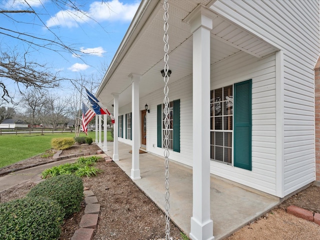 view of side of property featuring fence and a porch