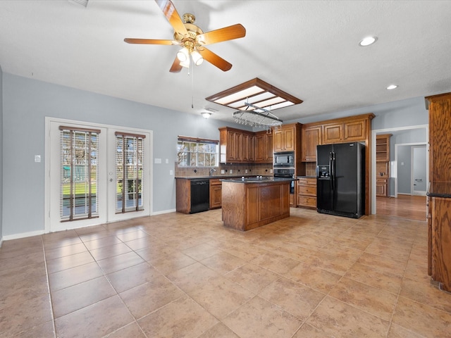 kitchen featuring dark countertops, brown cabinets, a center island, french doors, and black appliances