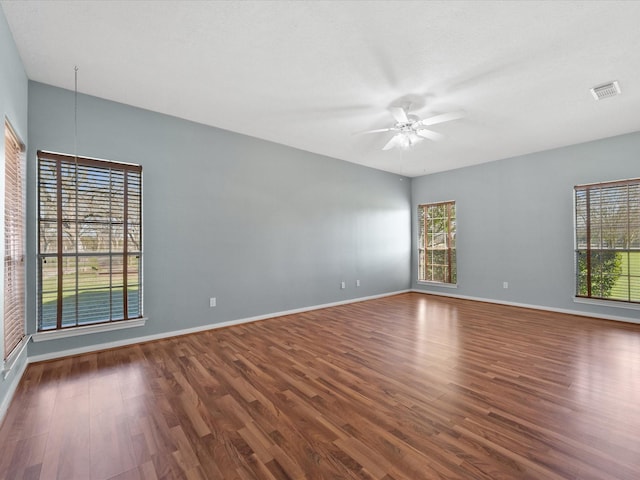 unfurnished room featuring dark wood-style floors, ceiling fan, and baseboards