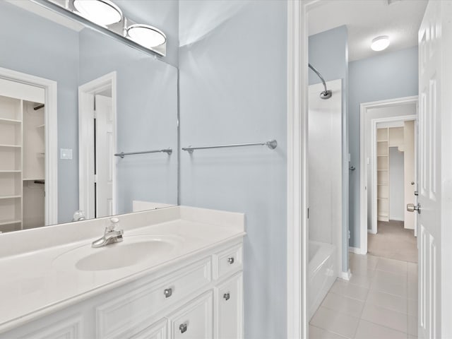 bathroom featuring tile patterned flooring, bathtub / shower combination, and vanity