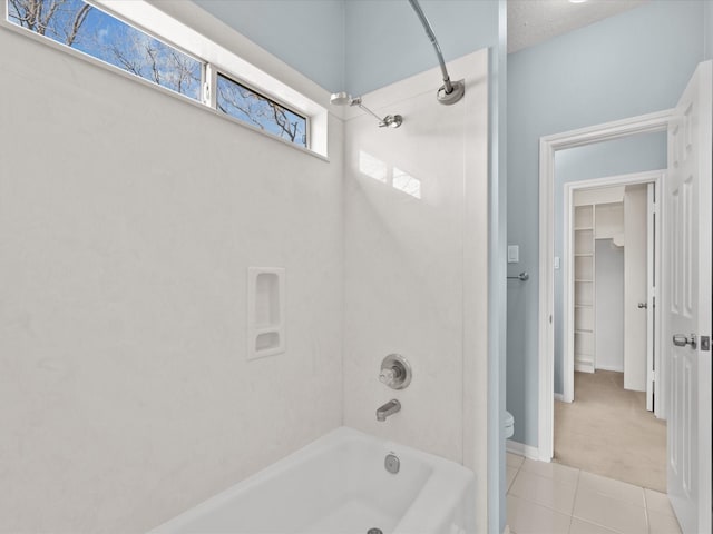 full bathroom with washtub / shower combination, tile patterned flooring, baseboards, and toilet