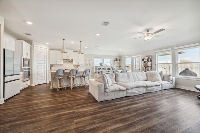 living room featuring dark hardwood / wood-style flooring and ceiling fan