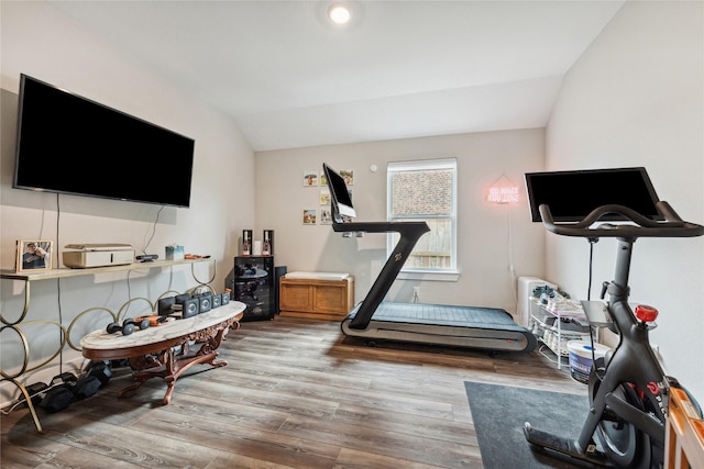 workout area with vaulted ceiling and hardwood / wood-style floors