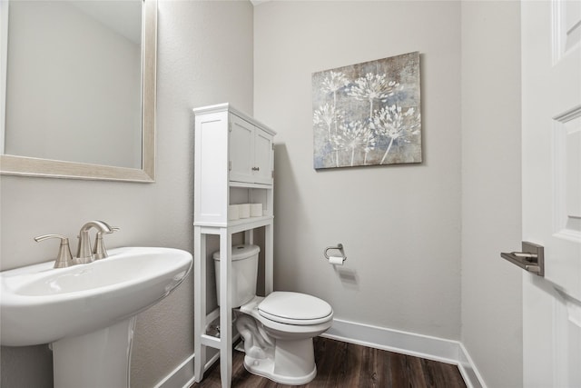 bathroom featuring hardwood / wood-style flooring, toilet, and sink