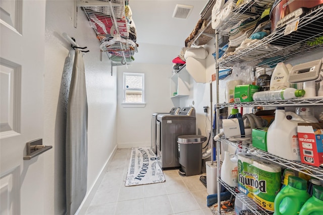 laundry area with light tile patterned floors and washer and dryer