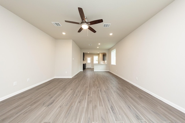 unfurnished living room featuring light wood-style floors, visible vents, and baseboards