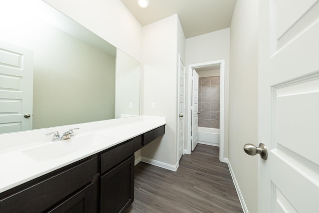 bathroom featuring vanity, baseboards, and wood finished floors