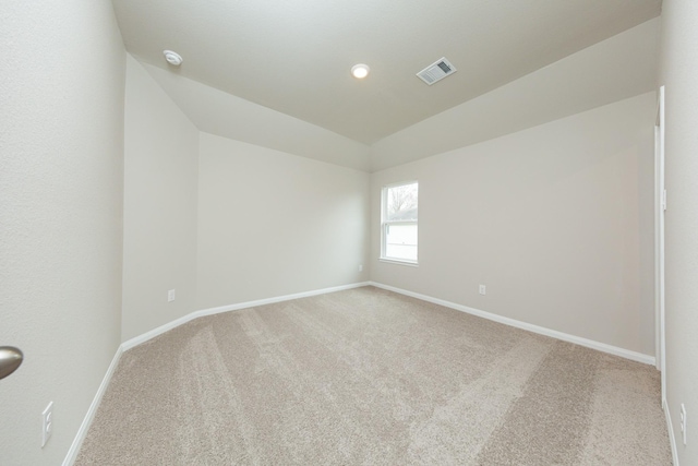 spare room featuring carpet, visible vents, and baseboards