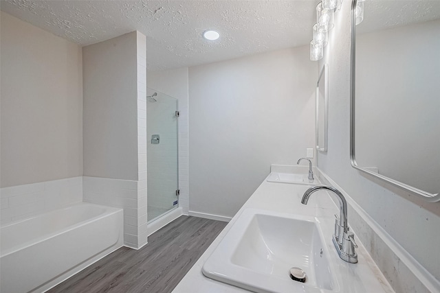 bathroom featuring hardwood / wood-style flooring, vanity, separate shower and tub, and a textured ceiling