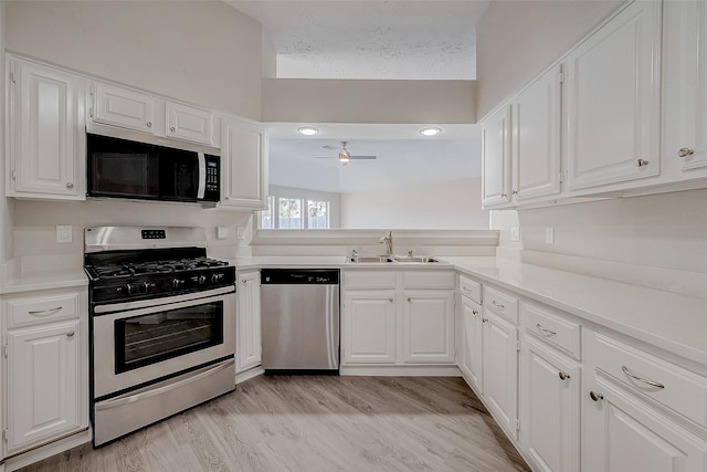 kitchen featuring sink, stainless steel appliances, light hardwood / wood-style floors, and white cabinets