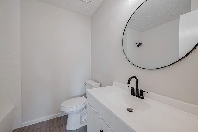 bathroom featuring hardwood / wood-style flooring, vanity, a textured ceiling, and toilet