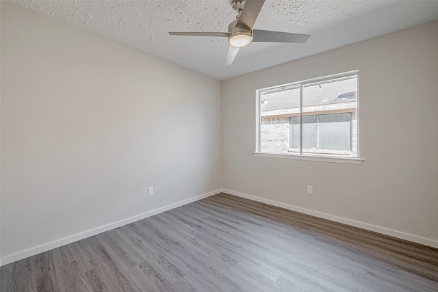 empty room with hardwood / wood-style flooring, ceiling fan, and a textured ceiling