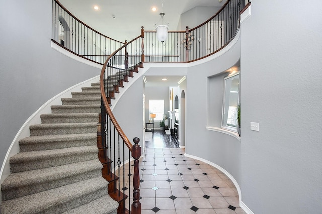 stairway featuring a high ceiling and a wealth of natural light