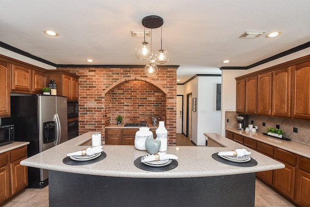 kitchen featuring crown molding, brick wall, a kitchen island, and black appliances