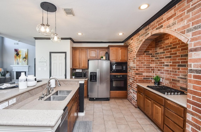 kitchen featuring decorative light fixtures, brick wall, sink, and black appliances