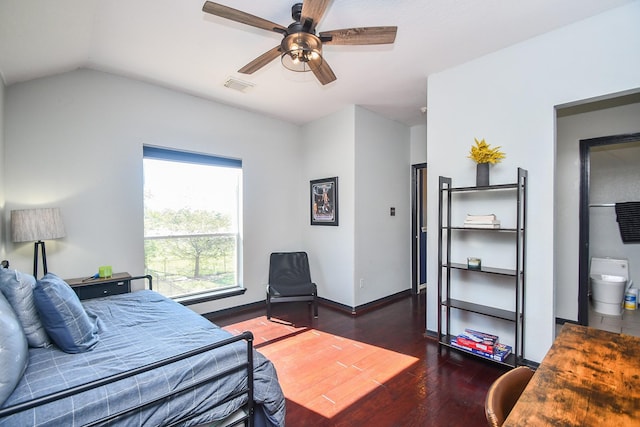 bedroom with vaulted ceiling, dark wood-type flooring, ceiling fan, and ensuite bath