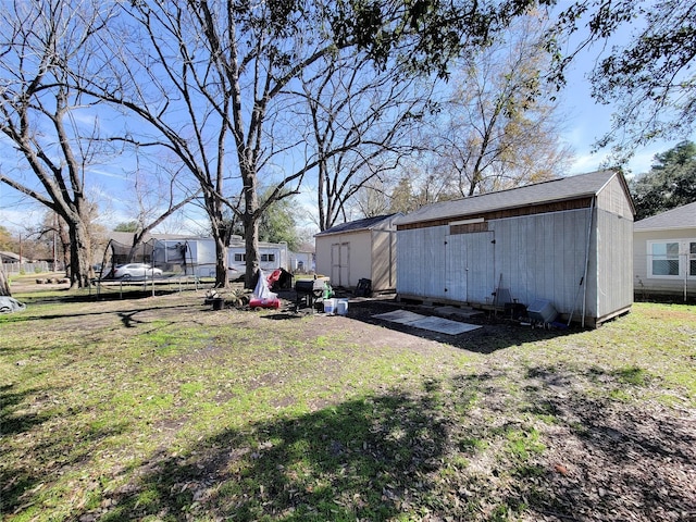 view of yard with a trampoline and a storage shed