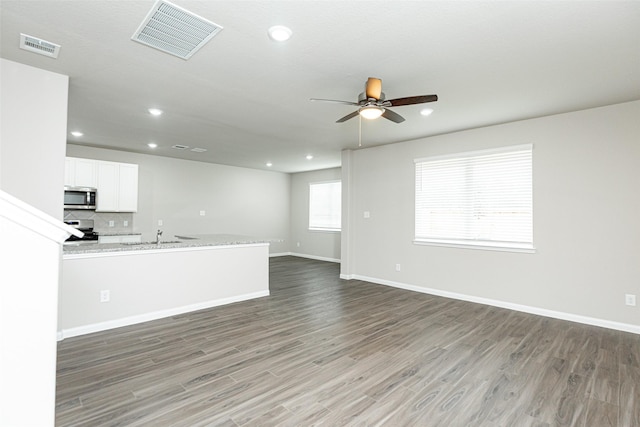 unfurnished living room with dark hardwood / wood-style floors, sink, and ceiling fan