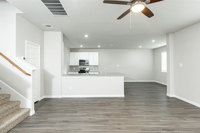 interior space with dark wood-type flooring and ceiling fan