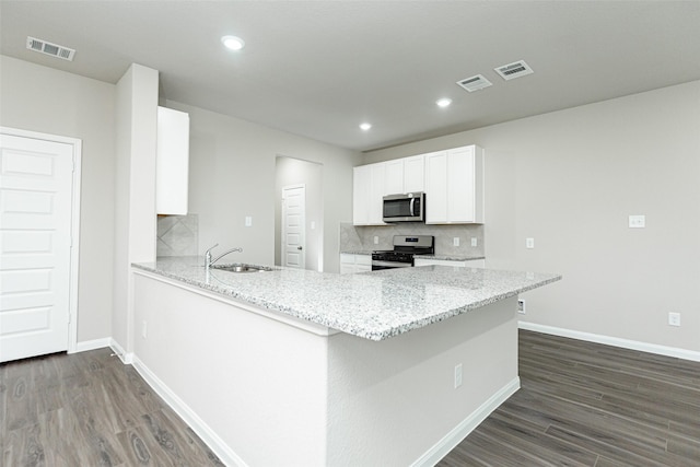 kitchen featuring sink, white cabinetry, stainless steel appliances, light stone counters, and kitchen peninsula