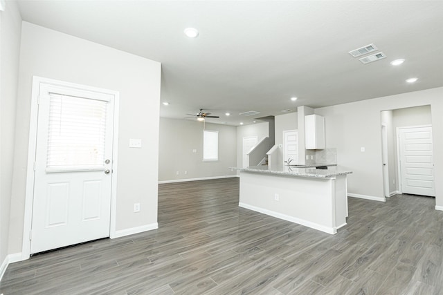 kitchen featuring backsplash, dark wood-type flooring, and white cabinets