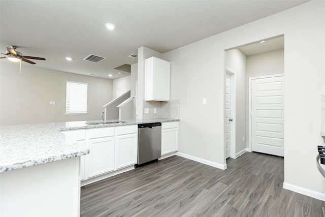 kitchen featuring hardwood / wood-style floors, white cabinetry, sink, stainless steel dishwasher, and light stone countertops