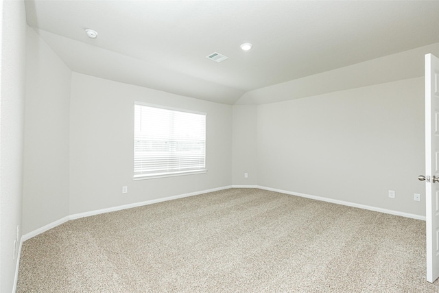 empty room with lofted ceiling and carpet floors